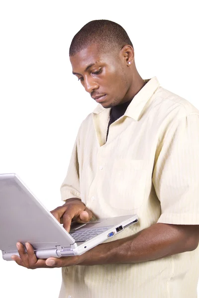 Junger schwarzer Mann steht und arbeitet am Laptop — Stockfoto