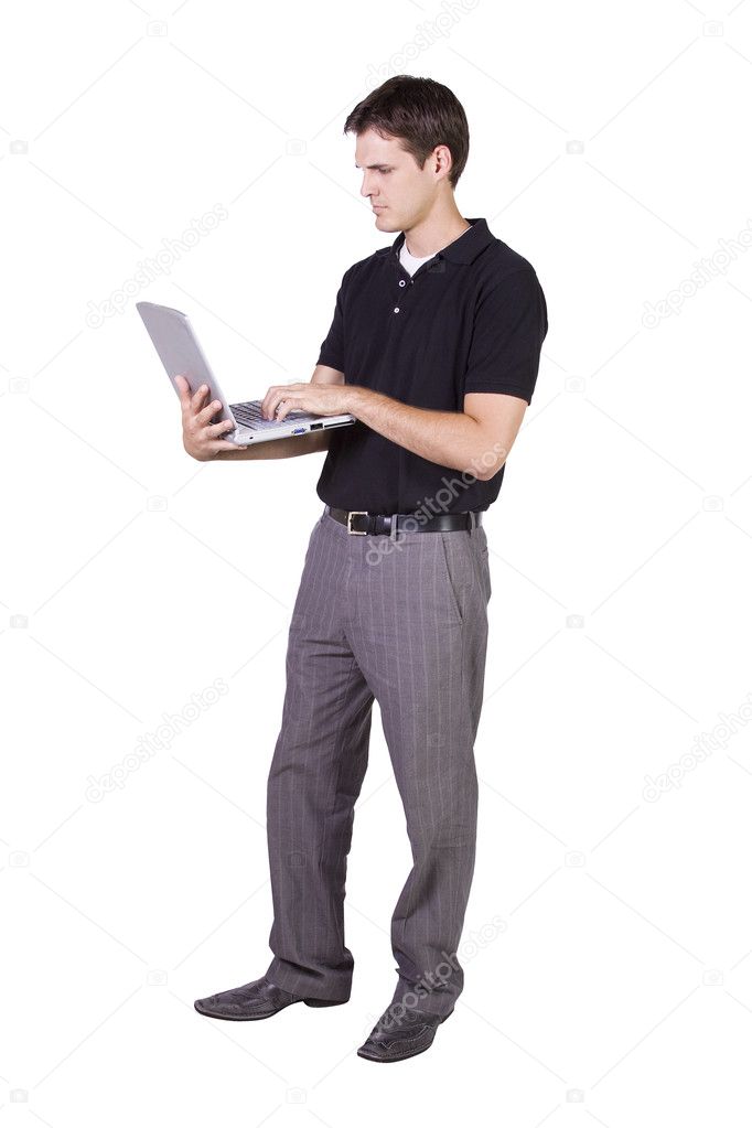 Young man standing and working on laptop