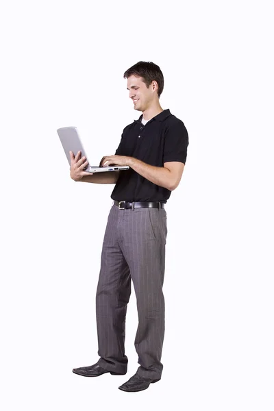 Junger Mann steht und arbeitet am Laptop — Stockfoto