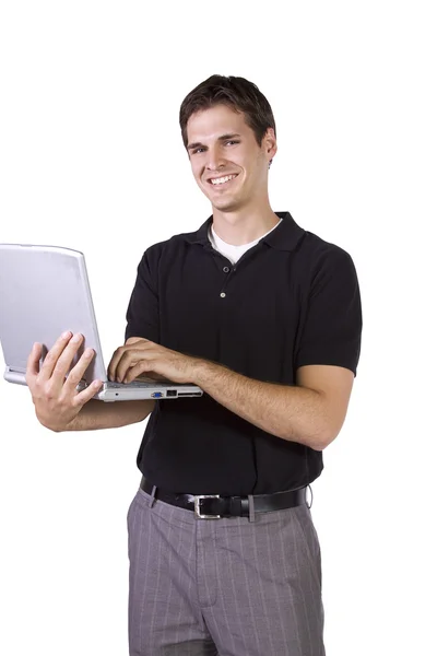 Молодой человек стоит и работает над ноутбуком — стоковое фото