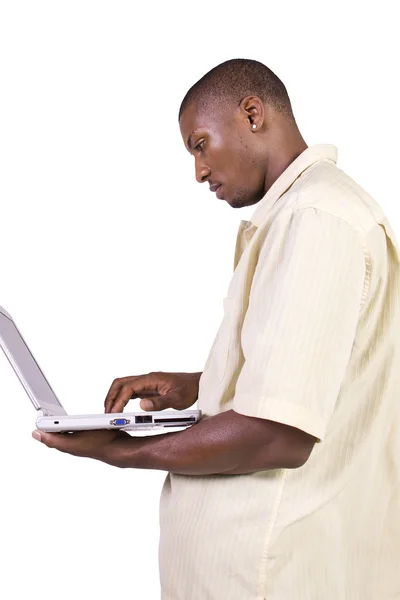 Giovane uomo nero in piedi e al lavoro sul computer portatile — Foto Stock