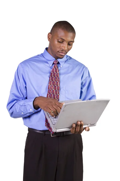 Joven hombre negro de pie y trabajando en el ordenador portátil —  Fotos de Stock