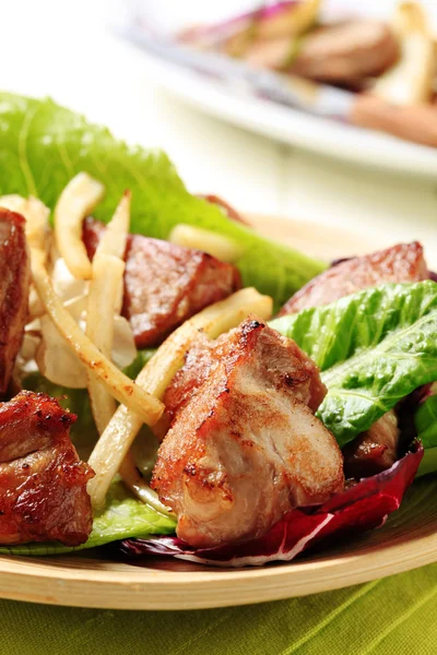 Pfanne gebratenes Schweinefleisch und Salat — Stockfoto