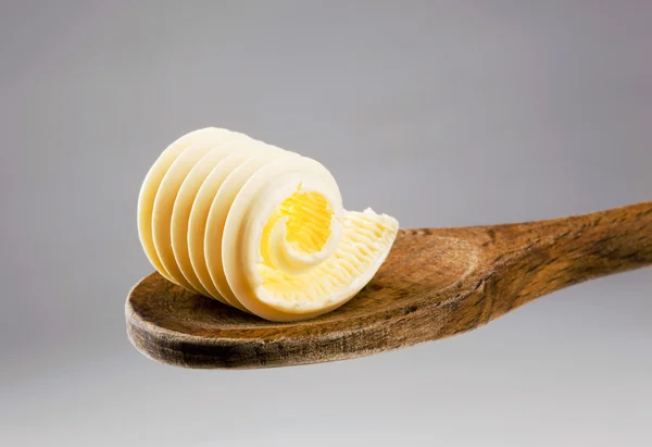 Βούτυρο μπούκλα σχετικά με ένα ξύλινο κουτάλι — Φωτογραφία Αρχείου