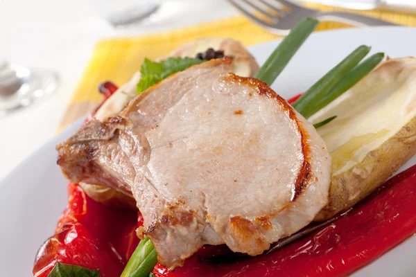 Roasted pork chop with potato and red peppers — Stock Photo, Image