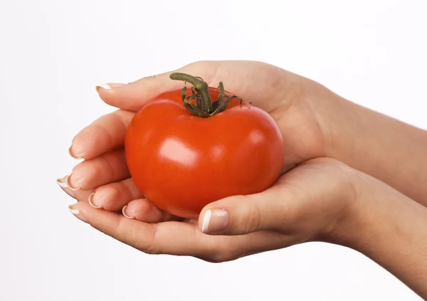 Kobieta w ręce trzymając czerwony pomidor — Zdjęcie stockowe