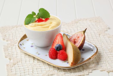 Bowl of creamy pudding and fresh fruit clipart