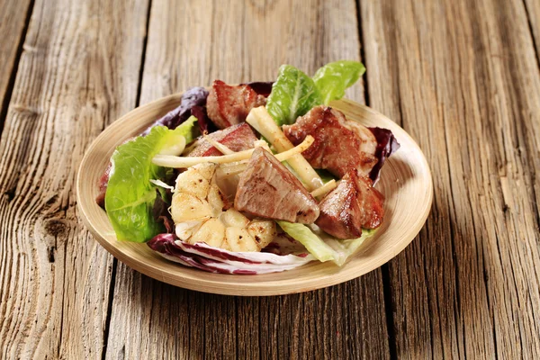 Жареная свинина и овощной салат — стоковое фото