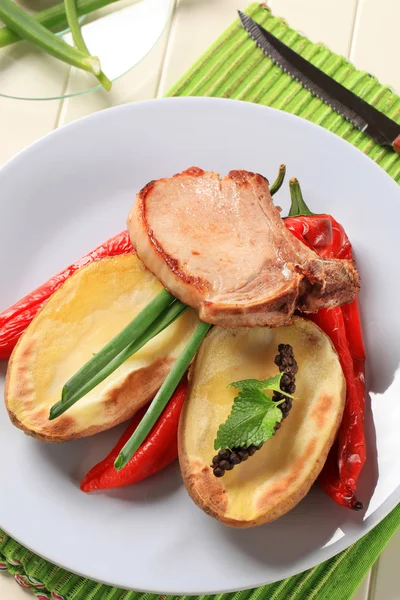 Pork chop with potato and red peppers — Stock Photo, Image