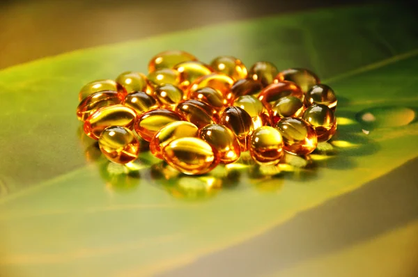 Pílulas amarelas no fundo verde — Fotografia de Stock