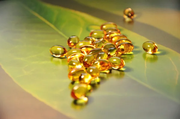 Κίτρινο χάπια σε πράσινο φόντο — Φωτογραφία Αρχείου