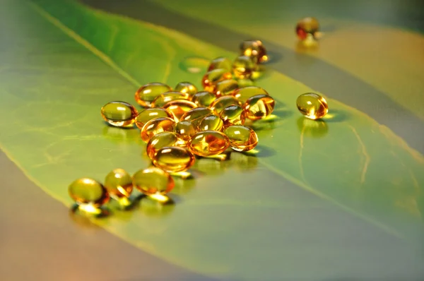Píldoras amarillas sobre fondo verde — Stockfoto