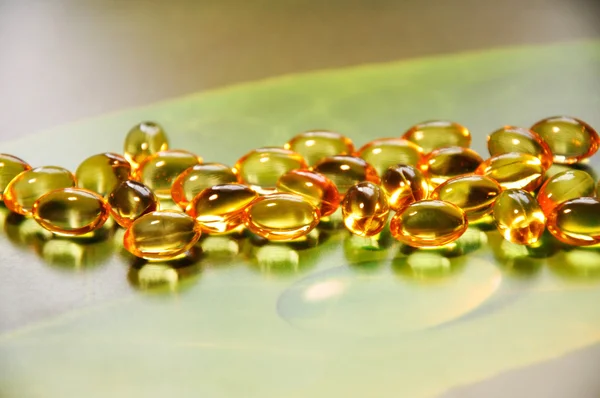 Yellow pills on green background — Stock Photo, Image
