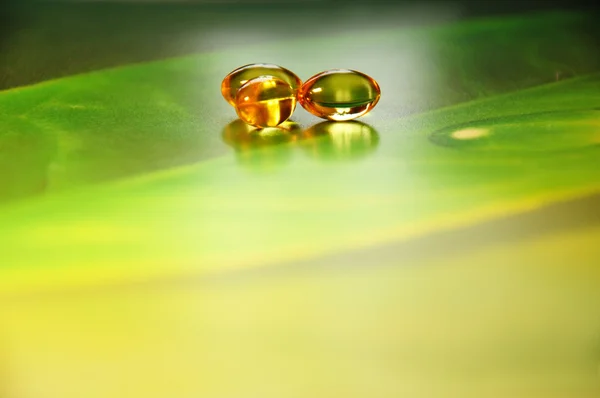 Жовті таблетки на зеленому тлі — стокове фото