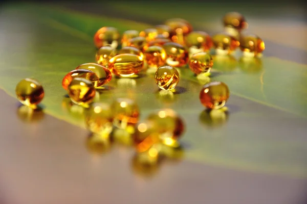 Pílulas amarelas no fundo verde — Fotografia de Stock