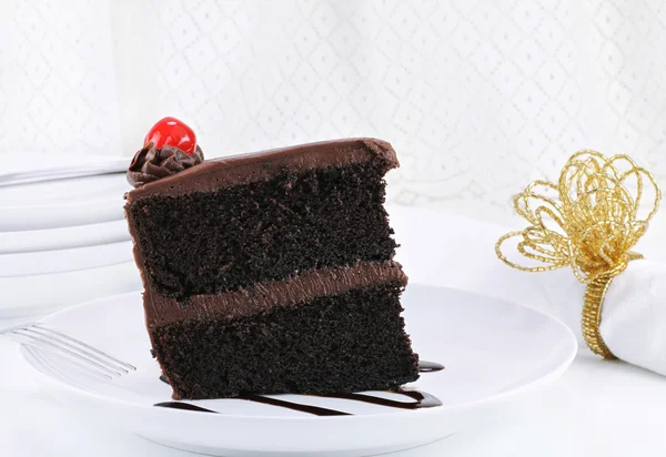 Gâteau au chocolat au caramel avec cerise dans un décor de table élégant — Photo
