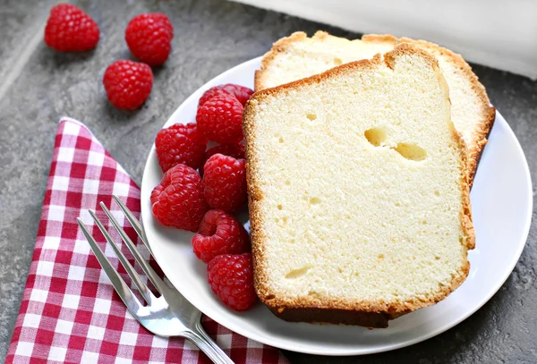 Two sliced fresh pound cake with raspberries. Selective focus on — Stock Photo, Image