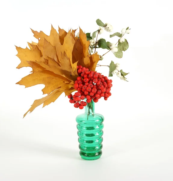Autumn Bouquet with ash and oak leaves in a vase with colored glass on a wh — Stock Photo, Image