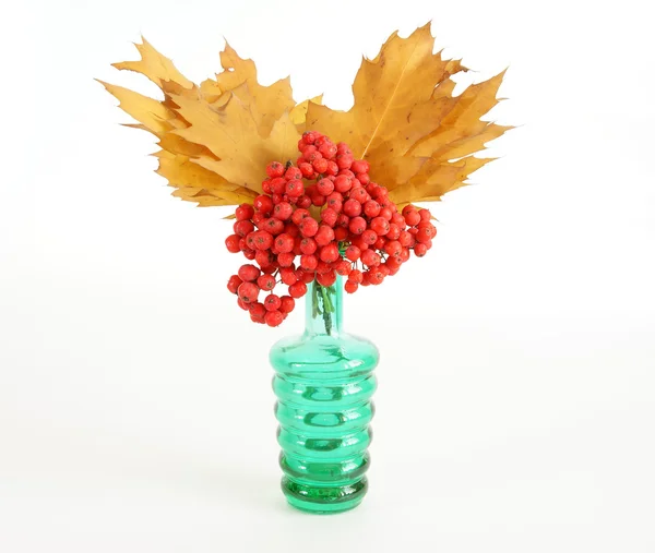 Otoño Bouquet con fresno y hojas de roble en un jarrón con vidrio de color en un wh — Foto de Stock