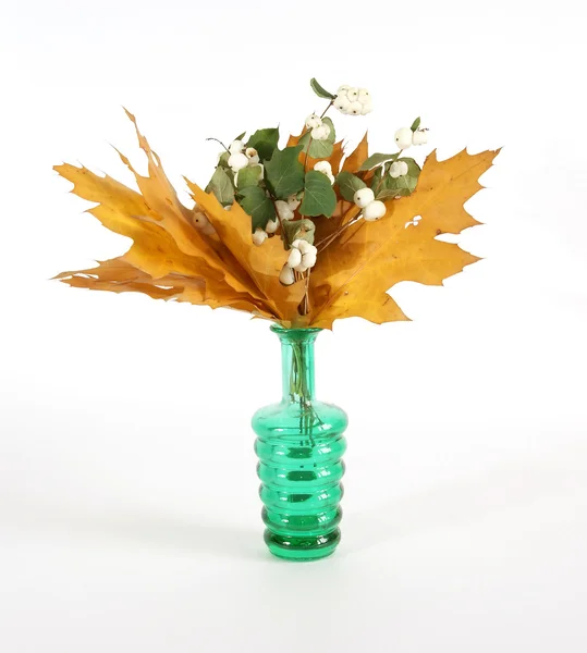 Herbststrauß aus Eichenblättern in einer Vase mit farbigem Glas auf weißem Hintergrund — Stockfoto