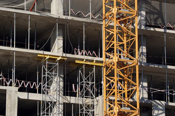 Bygga kran på bakgrunden av ett flera våningar byggnad under konstruktion — Stockfoto