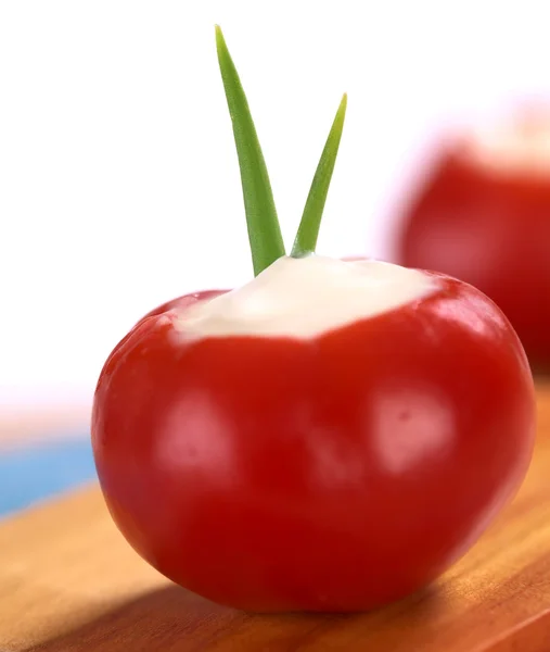 Маленький горячий красный перец, наполненный кислым кремом — стоковое фото