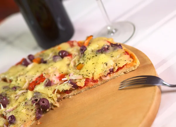 Пицца на деревянной тарелке — стоковое фото