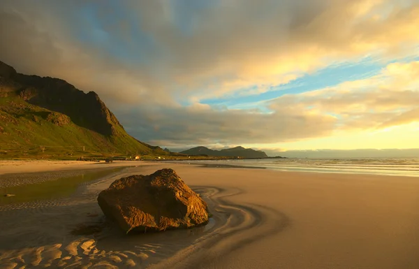 Roca en la playa iluminada por el sol de medianoche noruego — Foto de Stock