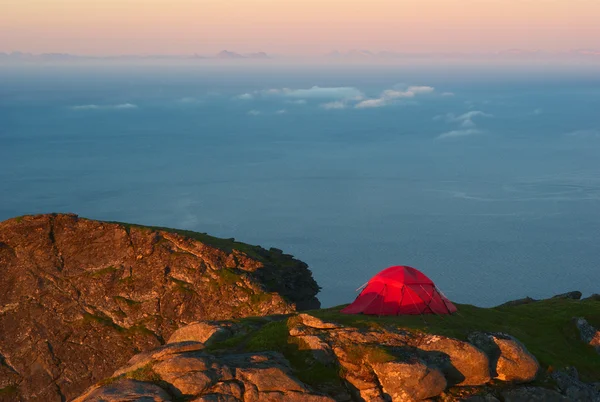 Палатка на горном хребте возле полуночного солнца — стоковое фото