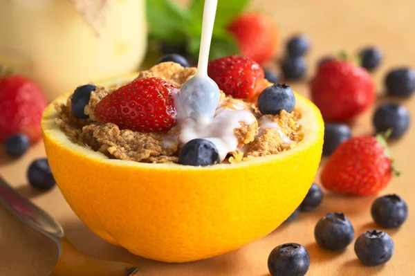 Verter leche sobre el cereal de trigo integral con frutas frescas —  Fotos de Stock