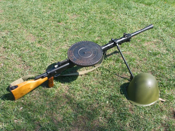 stock image Machine gun and military helmet on green grass