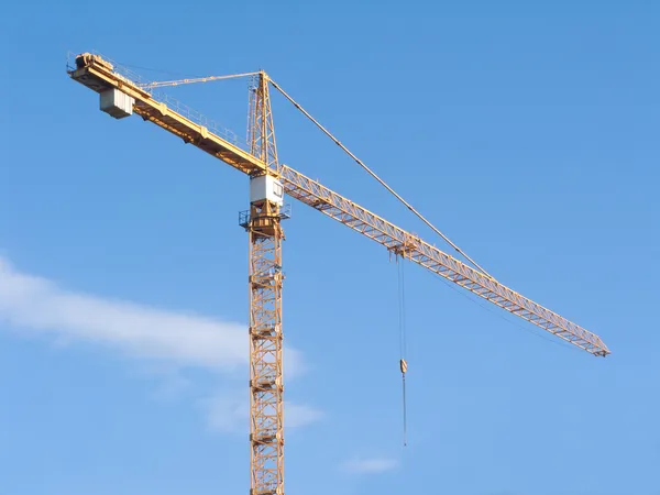Yellow construction hoisting crane on clear blue sky — Stock Photo, Image