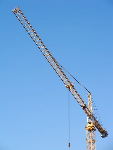 Grúa de elevación de construcción amarilla sobre cielo azul claro vertical — Foto de Stock