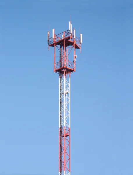Röda och vita cellular torn med antenner på blå himmel — Stockfoto