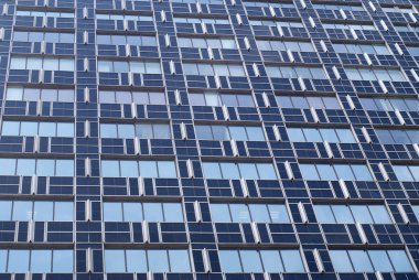 View of modern glass and metal blue building with many windows clipart