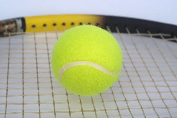 Teil des Tennisschlägers mit flauschigen gelben Ball Nahaufnahme — Stockfoto