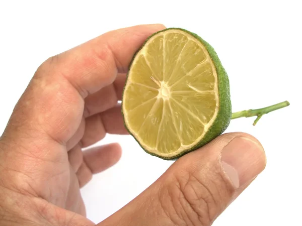 Metade de limão verde na mão isolado em branco — Fotografia de Stock