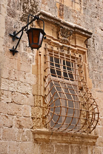 Уличная лампа и решетчатое окно в Старом городе Мдина, Мальта — стоковое фото
