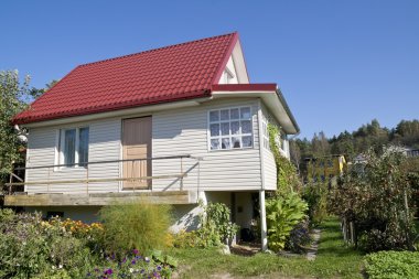 Flowers near simple rural house clipart