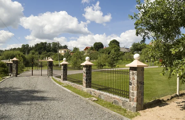 Beautiful stone fence with iron lattices — Stock Photo, Image