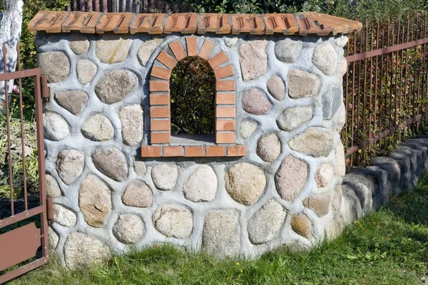 Фрагмент каменного забора с железными решетками — стоковое фото