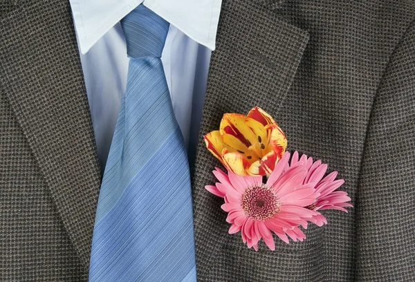 Bloemen in een zak van een bruine jas — Stockfoto