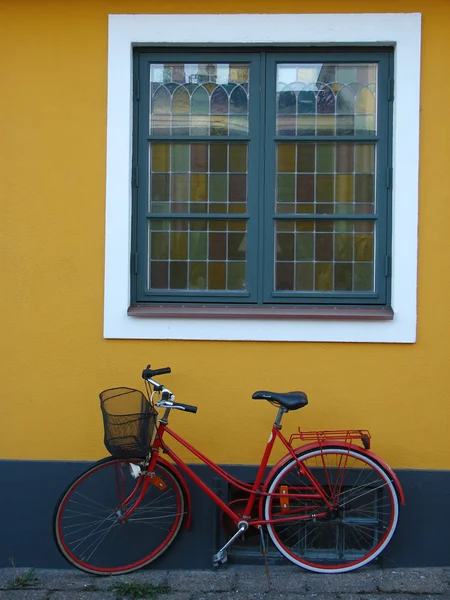 Yellow wall with windows and bicycle — Stock Photo, Image