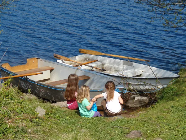 Маленькие девочки играют рядом с лодками — стоковое фото