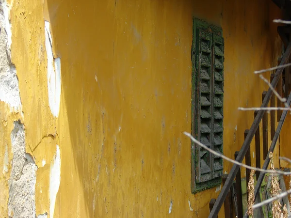 Gelbe Wand mit grünem Fenster — Stockfoto