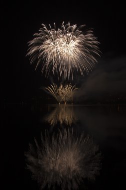 Colorful fireworks on the black sky background and water reflect clipart