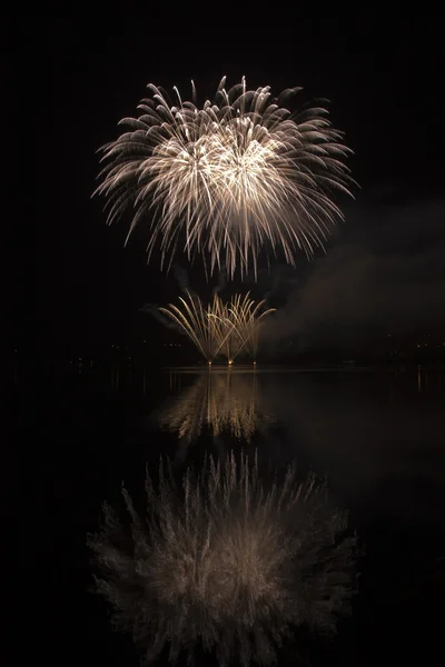 Fuochi d'artificio colorati sullo sfondo cielo nero e acqua riflettono — Foto Stock