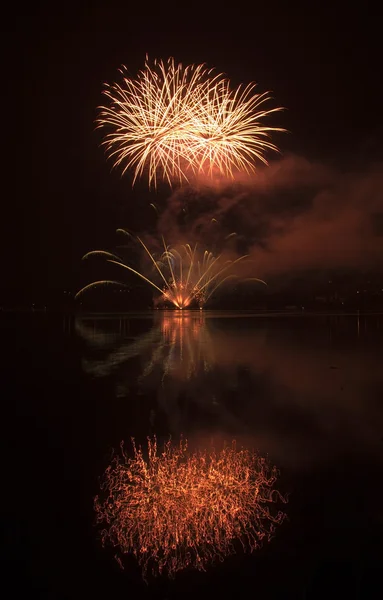 Colorful fireworks on the black sky background and water reflect — Stock Photo, Image