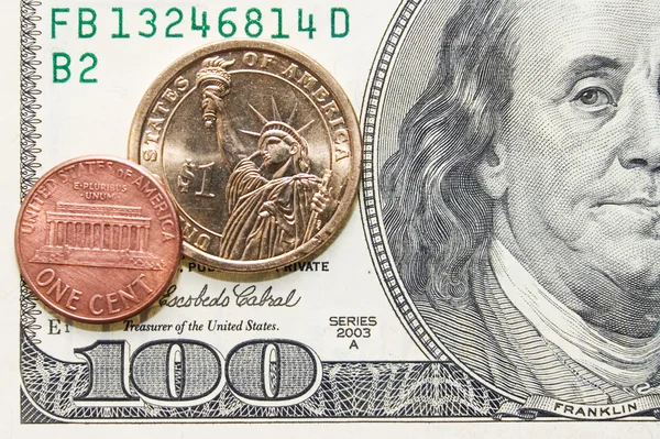 Ein-Cent-Münzen und Dollarmünzen auf Hundertschein — Stockfoto