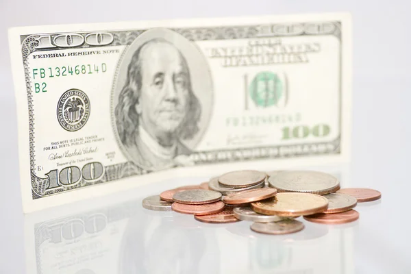100 dolarlık banknot karşı çok sayıda sikke — Stok fotoğraf